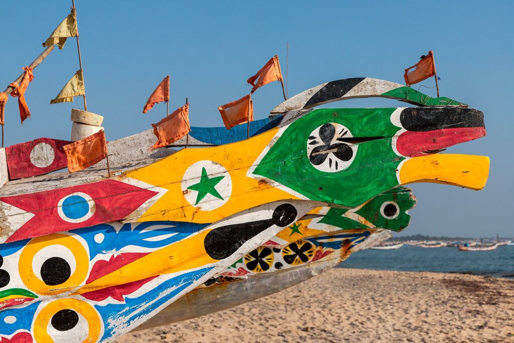 The painted prow of a fishing pirogue on a Casamance beach.